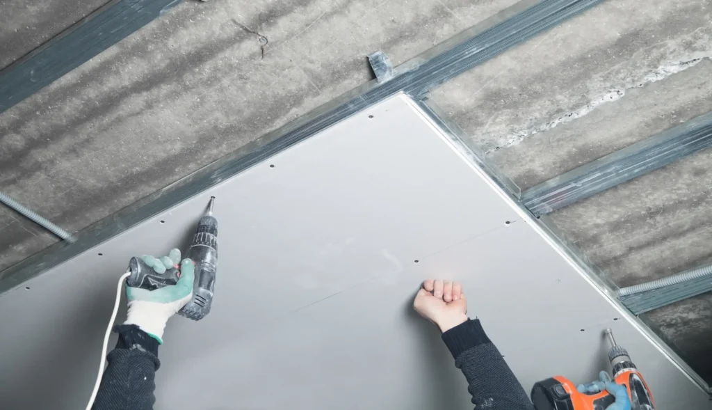 Workers installing gypsum boards for smooth and durable ceilings